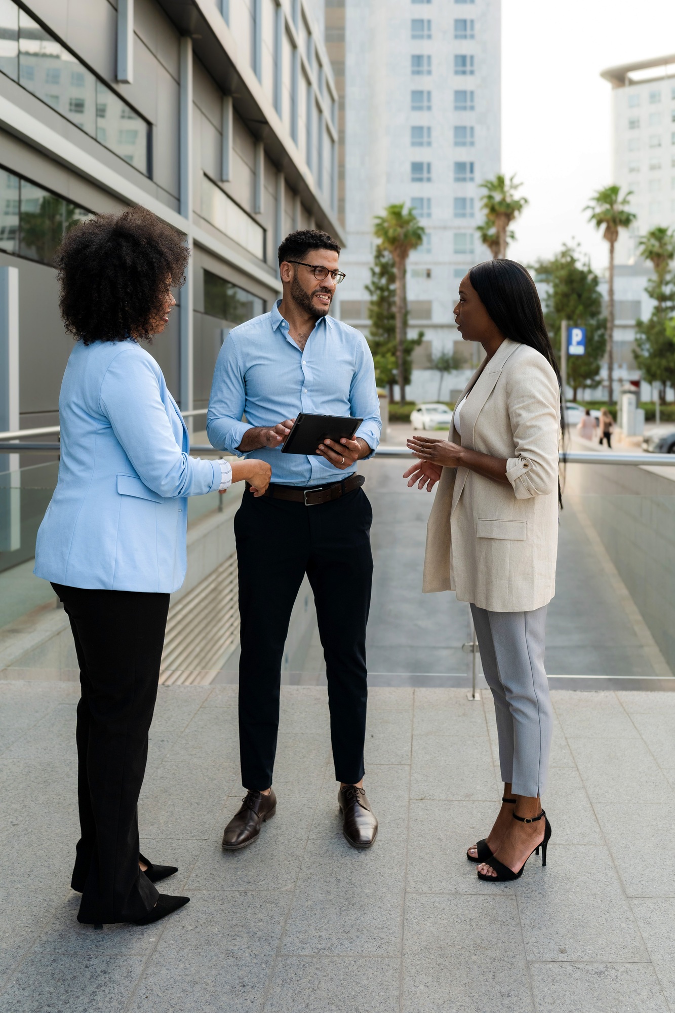 Multiracial Business team discussing a project using a digital tablet outside office buildings